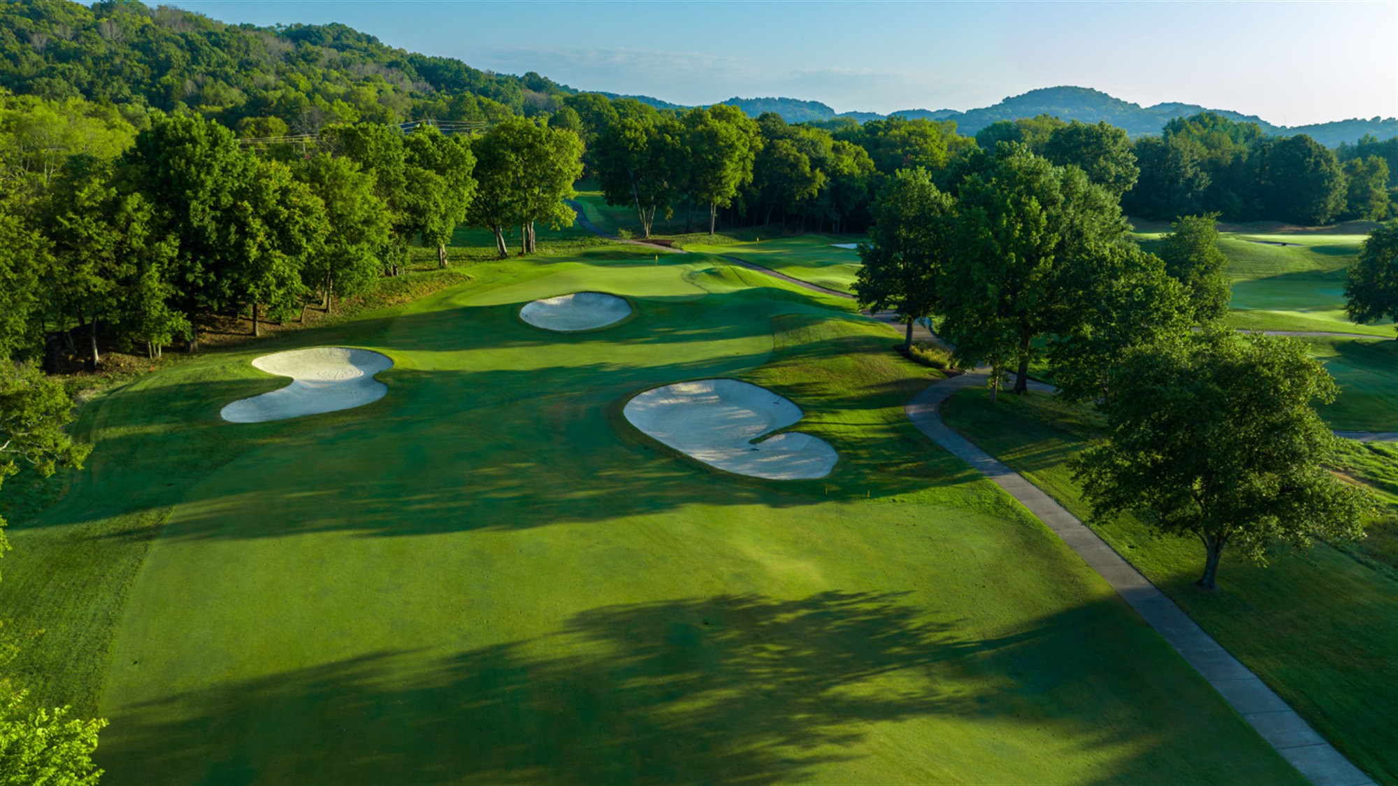 Aerial view of bunkers and a tree-lined fairway at Vanderbilt Legends Club